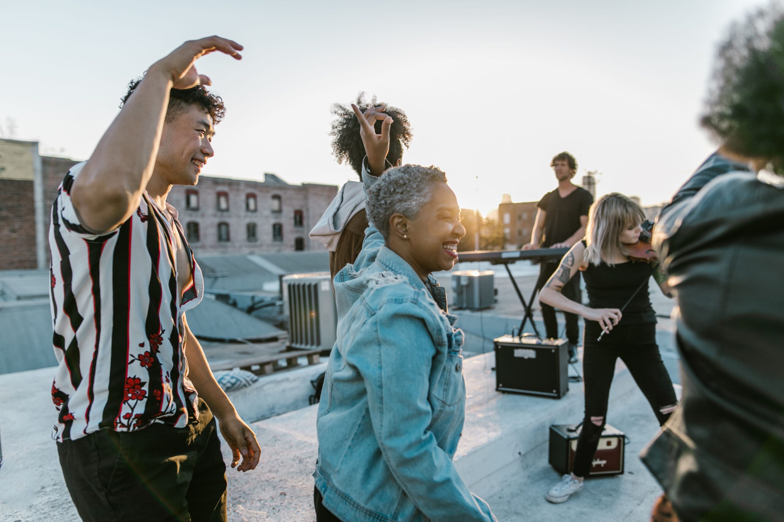 Musiciens et danseurs réunis sur un toit au coucher du soleil, photographie RDNE